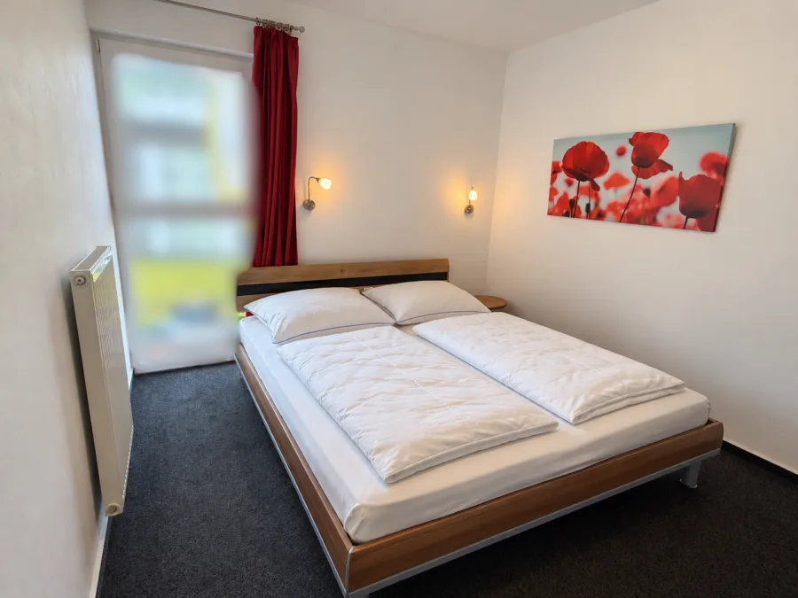 Meer, Strand & Erholung ganz nah- Ferienwohnung 51.3.S im Nordsee Ferienpark Schillig - Helles modernes Schlafzimmer mit Mohnblumenbild - bearbeitet (50666)
